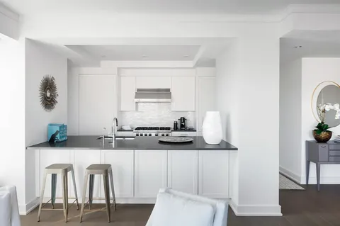 a kitchen with stainless steel appliances granite countertop a sink and a refrigerator