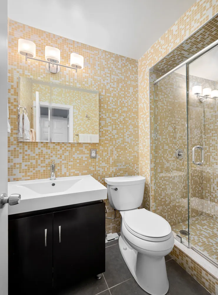 a bathroom with a sink a toilet and shower