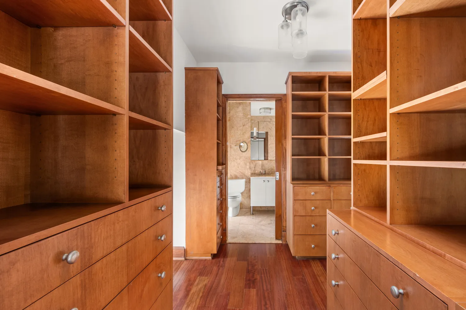 a view of walk in closet with wooden floor