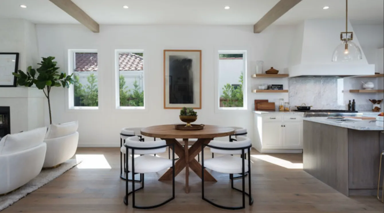 a kitchen with stainless steel appliances kitchen island granite countertop a table chairs sink and cabinets