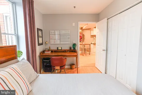 a bedroom with a bed and wooden floor