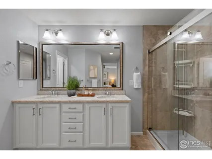 a bathroom with a granite countertop sink toilet a mirror and shower