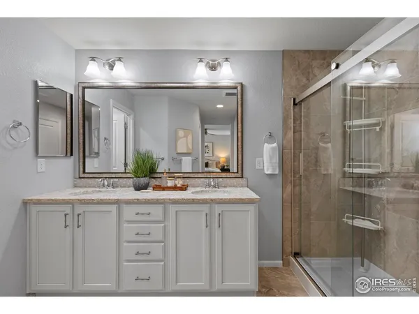 a bathroom with a granite countertop sink toilet a mirror and shower