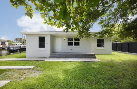 a front view of a house with a garden and yard