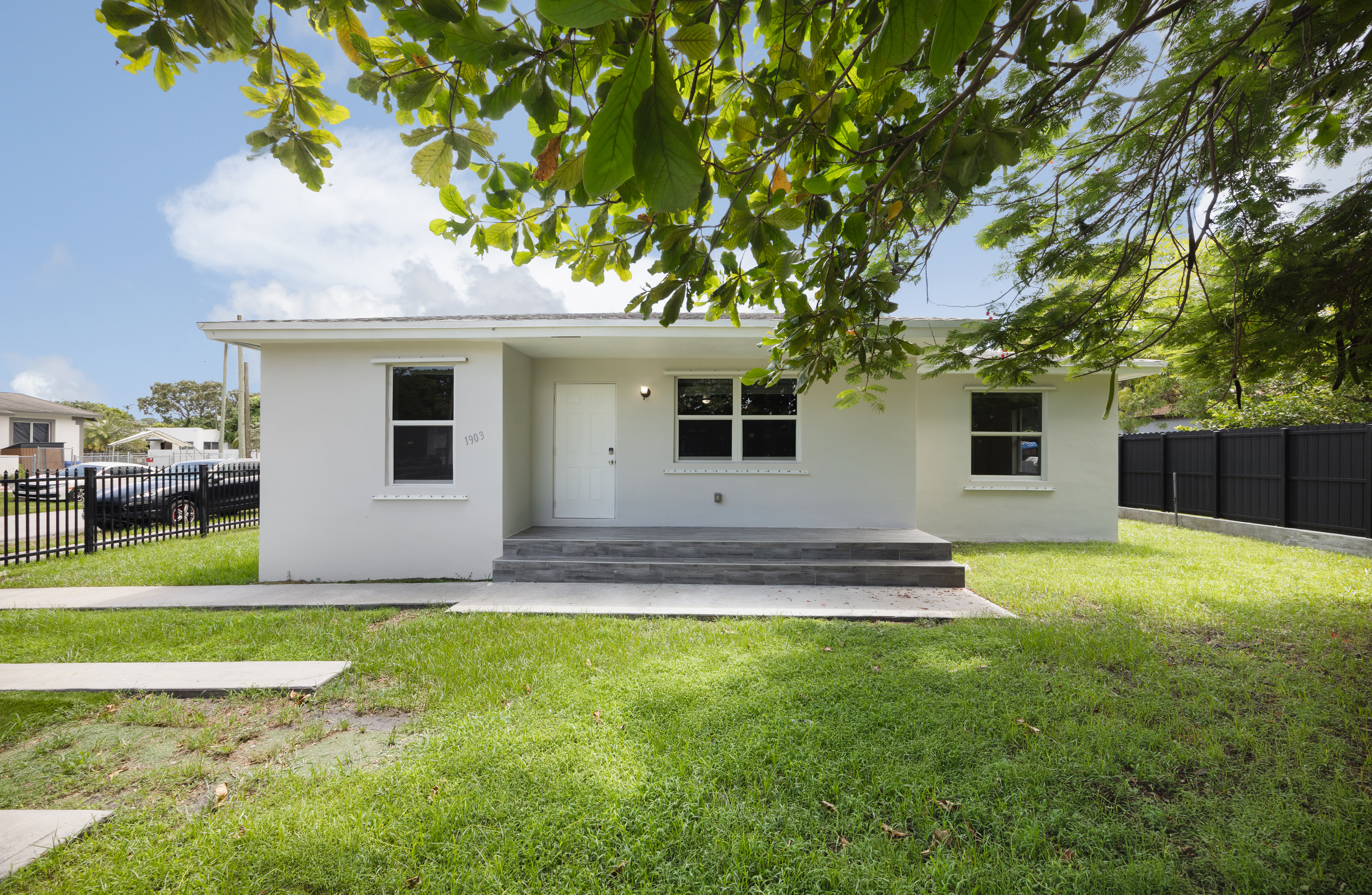 a front view of a house with a garden and yard