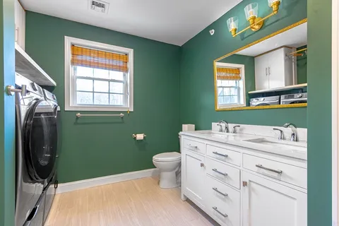 a bathroom with a toilet sink and mirror