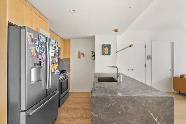 a kitchen with stainless steel appliances granite countertop a refrigerator and a sink