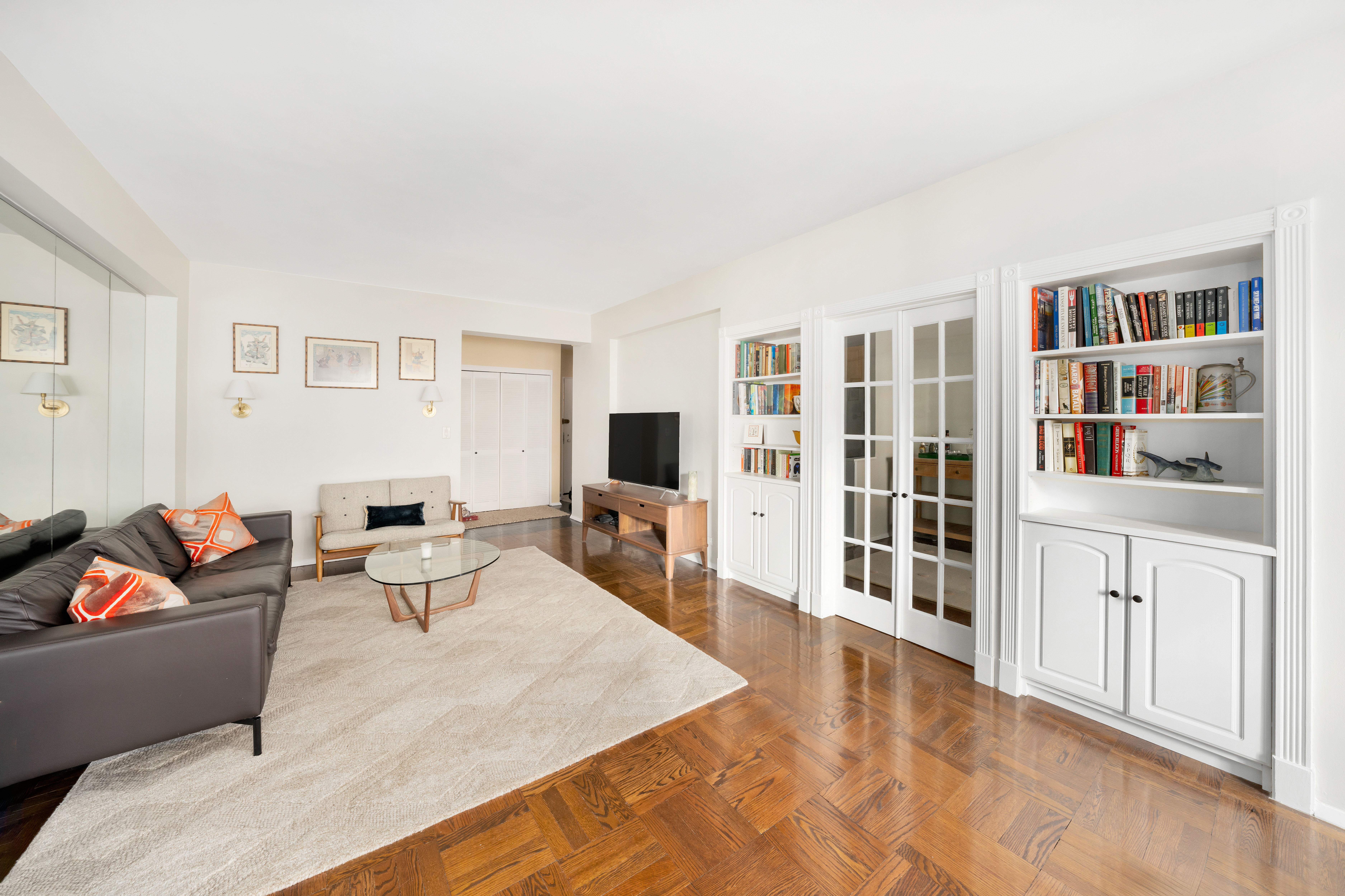 36 Sutton Place South, Unit 13D Manhattan, NY 10022 - Photo 2 of 9 a living room with furniture and a flat screen tv