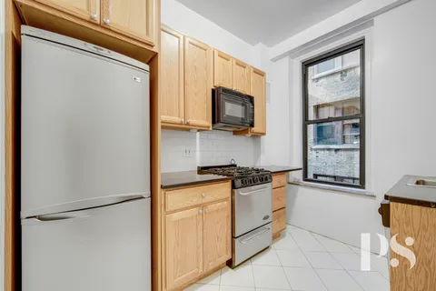 a kitchen with stainless steel appliances granite countertop a refrigerator a stove a sink a microwave and cabinets