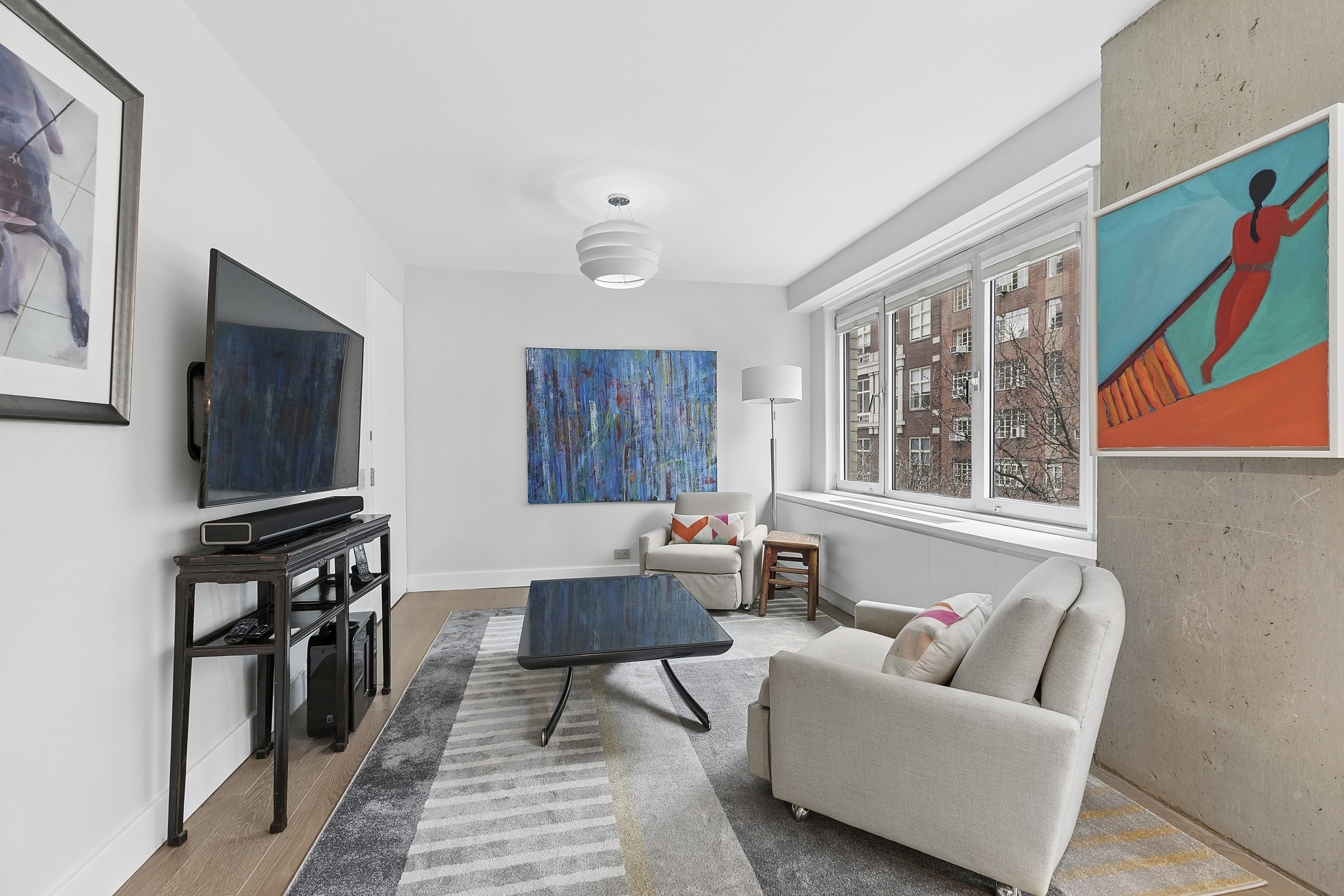 1065 Park Avenue, Unit 4BC Manhattan, NY 10128 - Photo 8 of 16 a living room with furniture and a flat screen tv