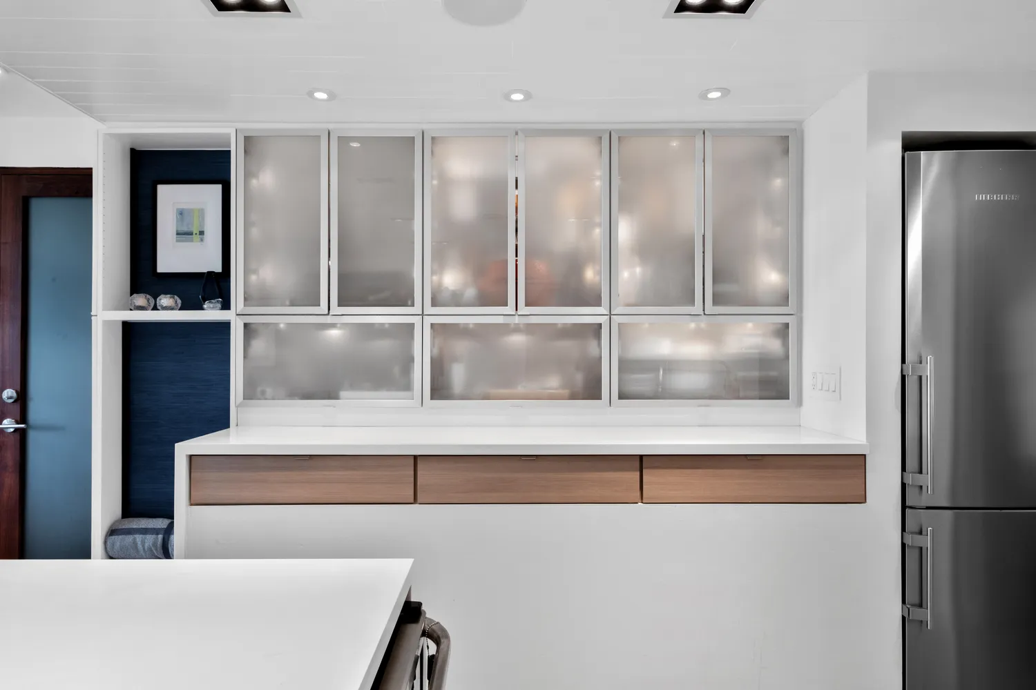 a kitchen with stainless steel appliances a stove and white cabinets