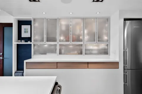 a kitchen with stainless steel appliances a stove and white cabinets