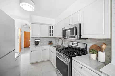 a kitchen with stainless steel appliances white cabinets and a stove