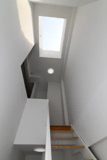 a spacious bedroom with a bed a couch and flat screen tv