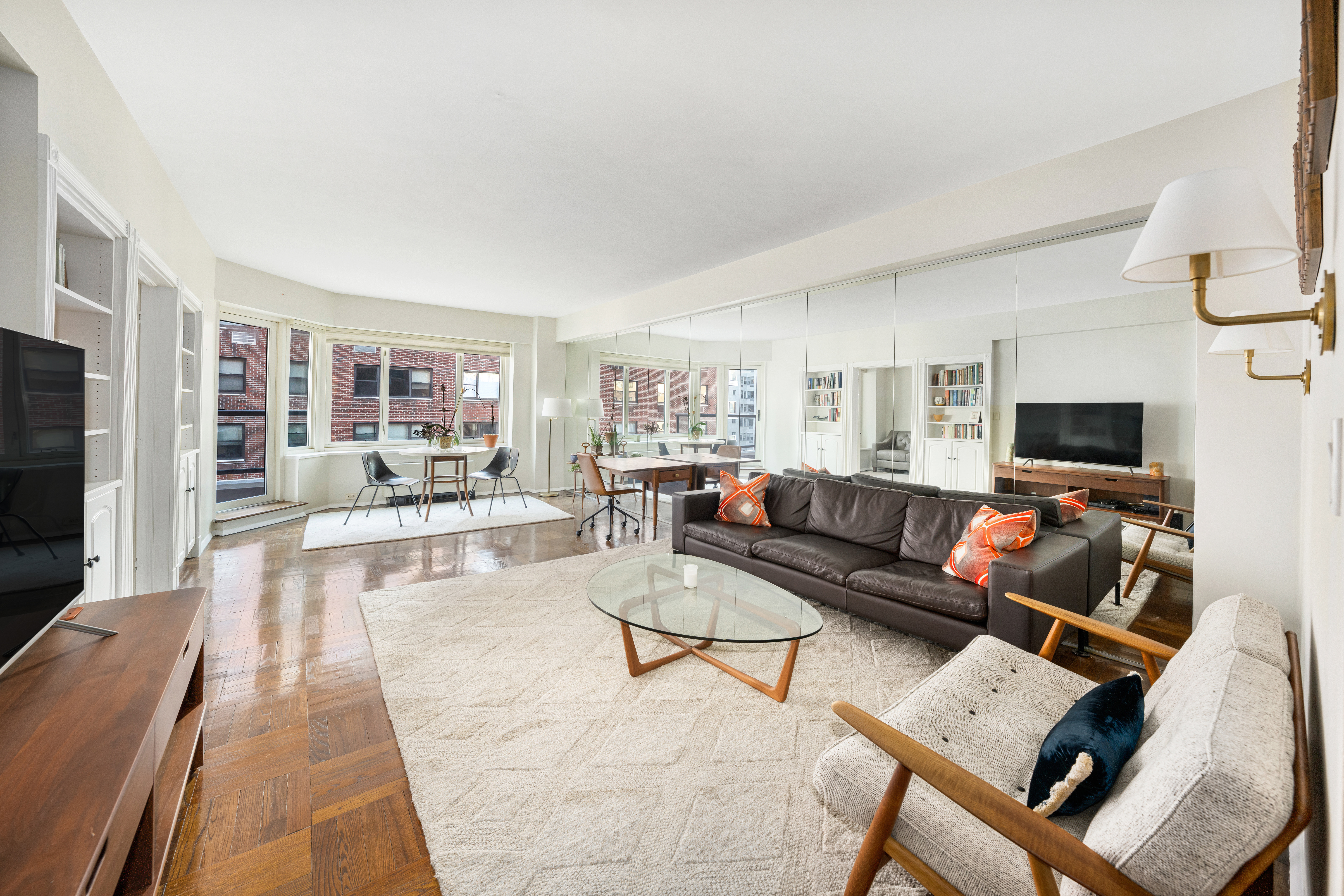 36 Sutton Place South, Unit 13D Manhattan, NY 10022 - Photo 3 of 9 a living room with furniture and a flat screen tv