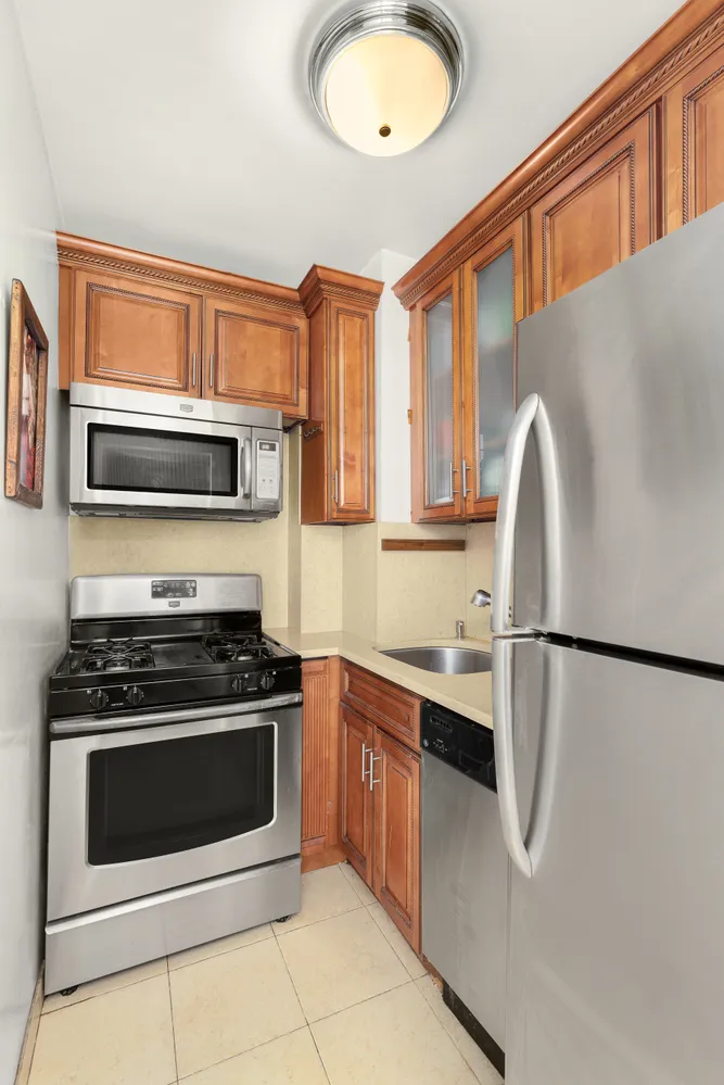 a kitchen with stainless steel appliances granite countertop a stove a sink and a refrigerator
