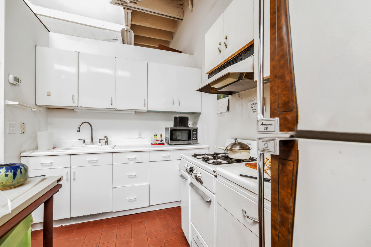 5-38 47th Road Queens, NY 11101 - Photo 10 of 14 a kitchen with stainless steel appliances a sink a stove and cabinets
