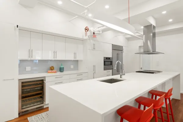 a kitchen with stainless steel appliances kitchen island a table chairs sink and cabinets