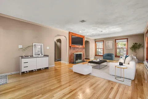 a living room with fireplace furniture and a large window