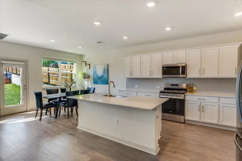 a kitchen with microwave a stove and cabinets