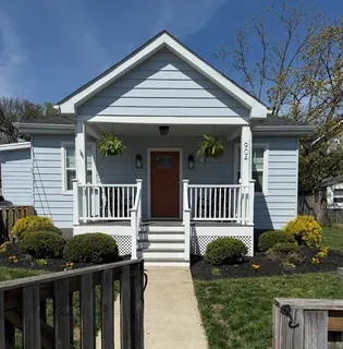 a view of a house with porch and wooden fence
