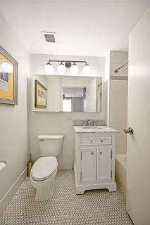 a bathroom with a granite countertop toilet sink and a mirror