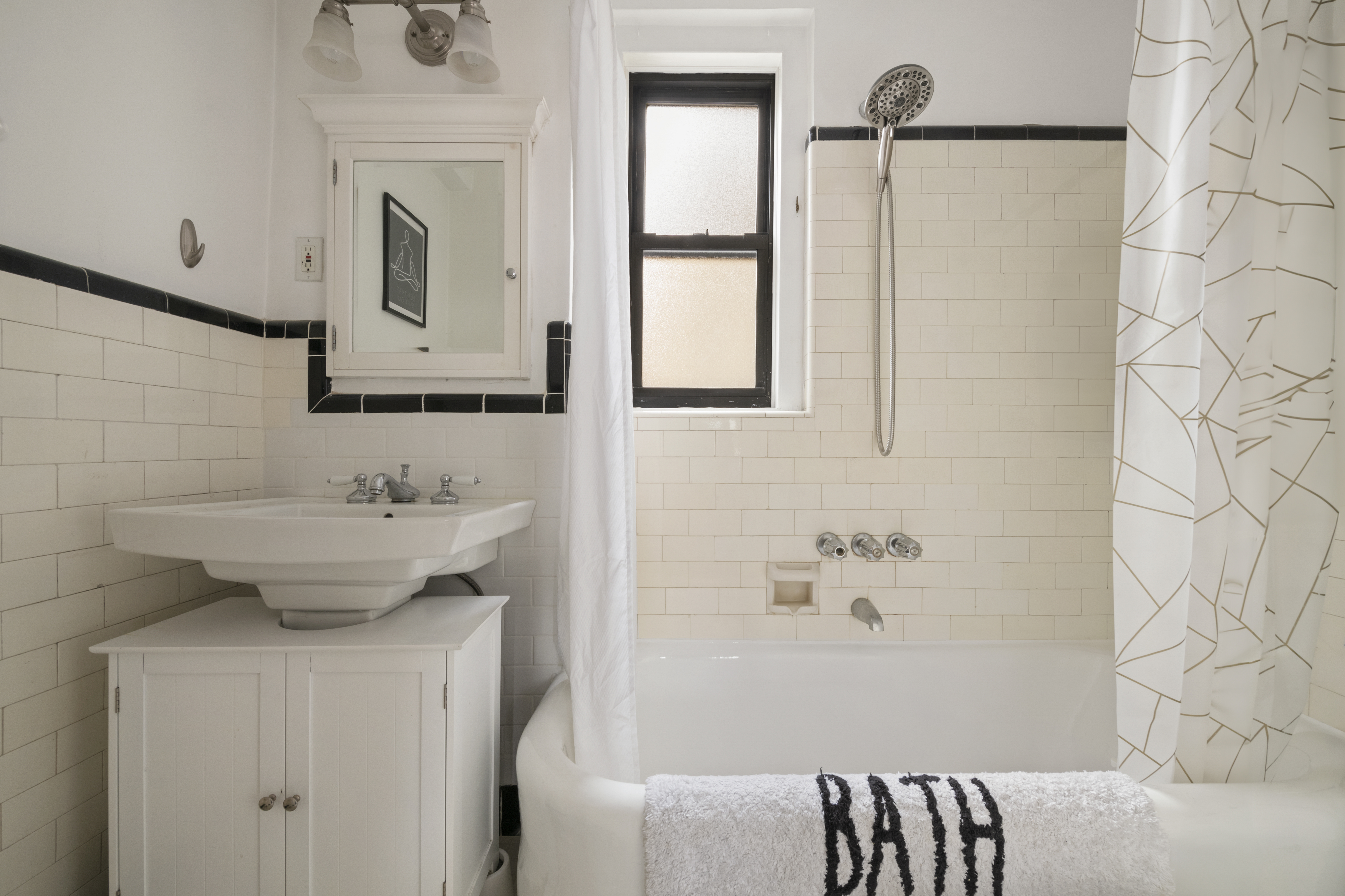 339 East 58th Street, Unit 9F Manhattan, NY 10022 - Photo 6 of 9 a bathroom with a sink a mirror and a bathtub