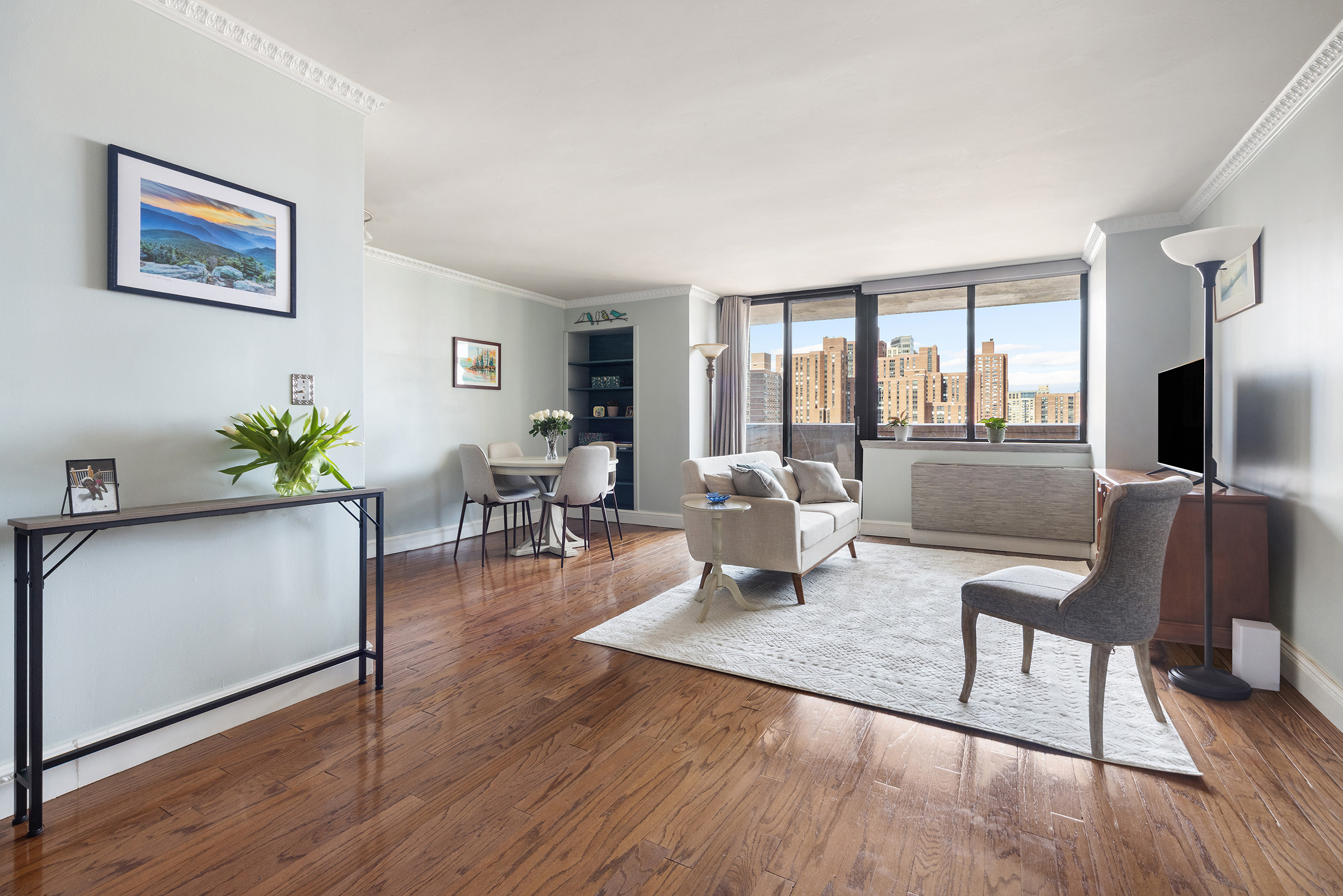 233 East 86th Street, Unit PHB Manhattan, NY 10028 - Photo 2 of 12 a living room with furniture large window and wooden floor
