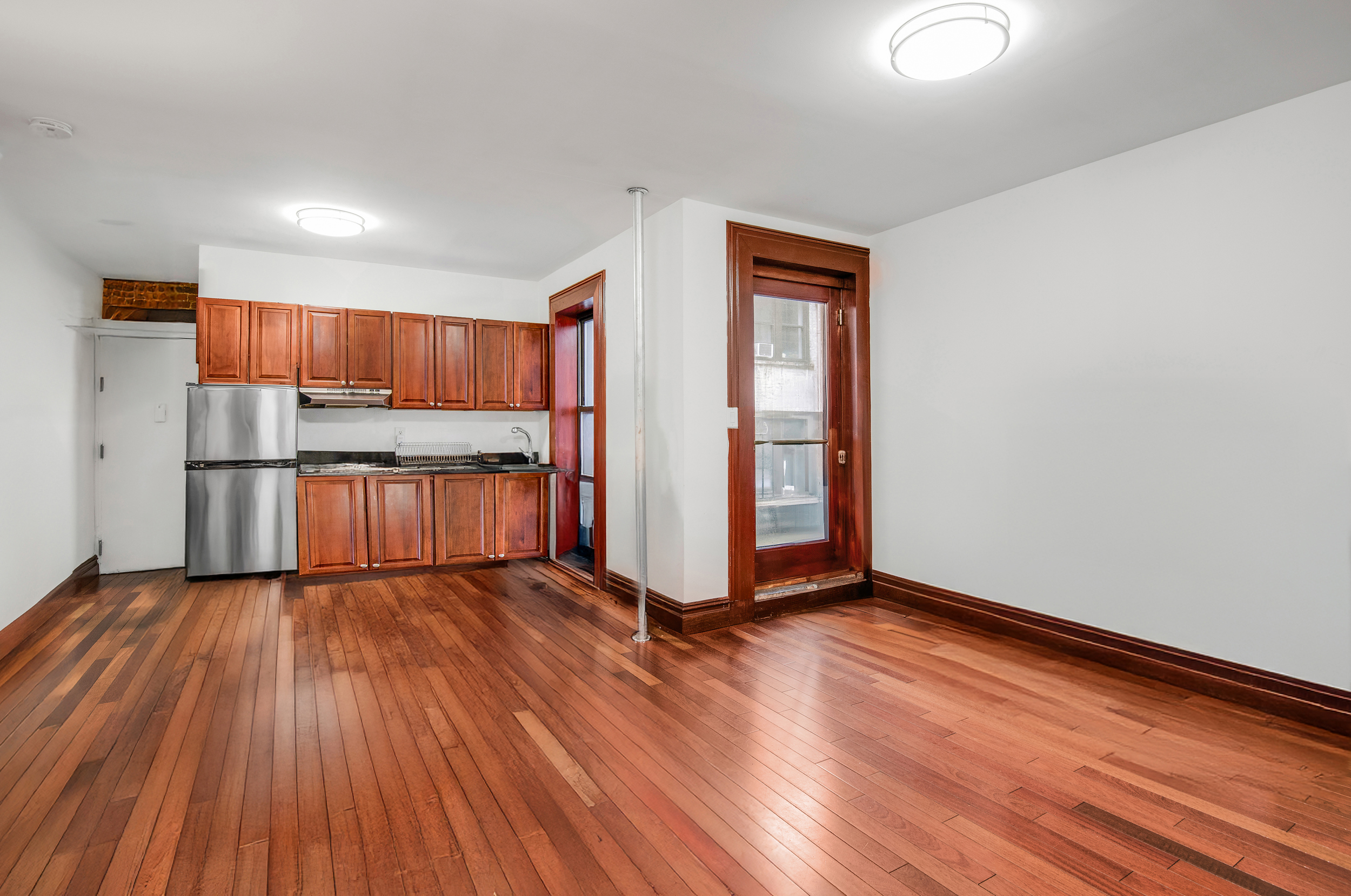 1392 Madison Avenue, Unit 28 Manhattan, NY 10128 - Photo 3 of 10 a view of kitchen with stainless steel appliances wooden floor and window