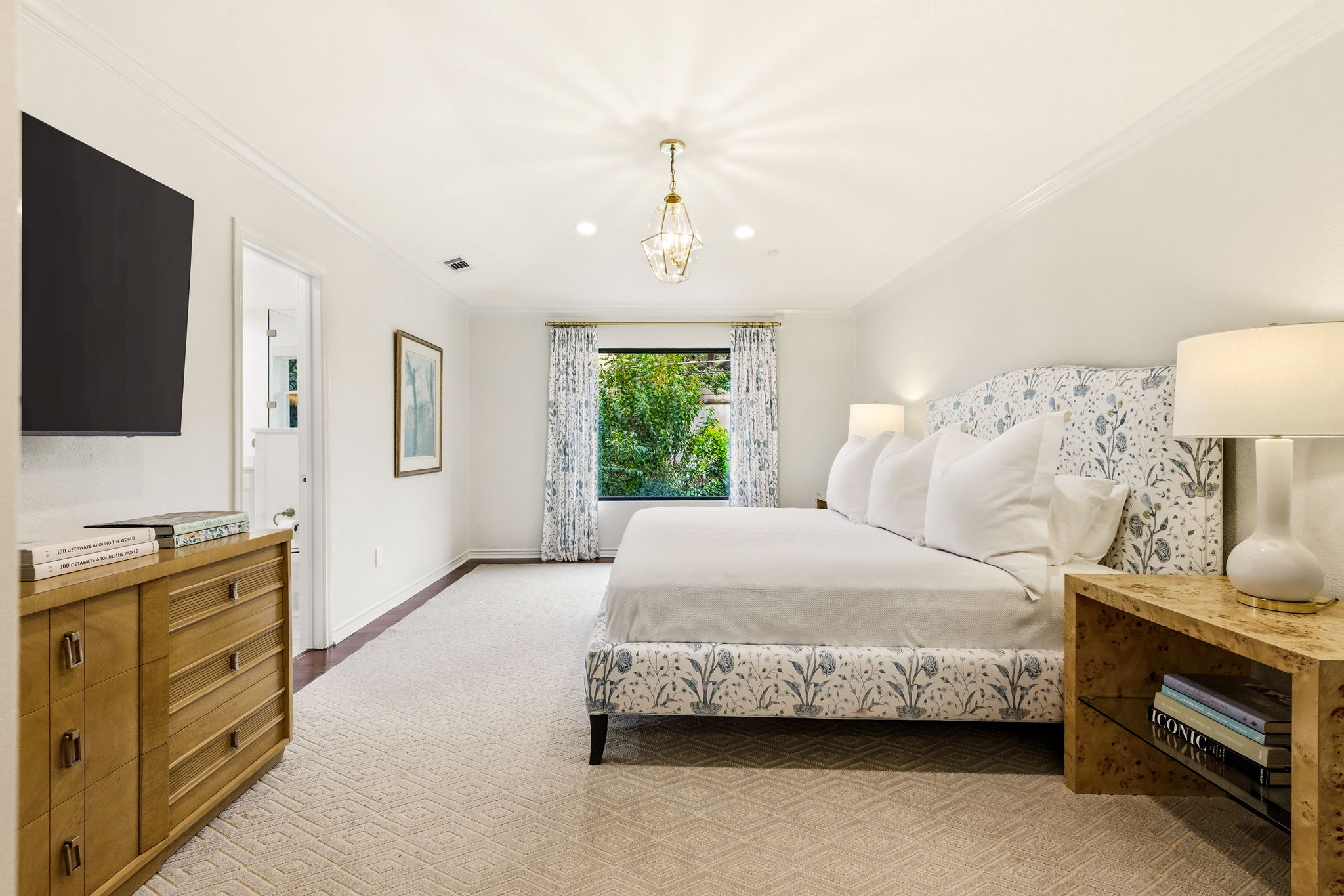 5765 Stonegate Road Dallas, TX 75209 - Photo 20 of 37 a spacious bedroom with a bed and a flat screen television