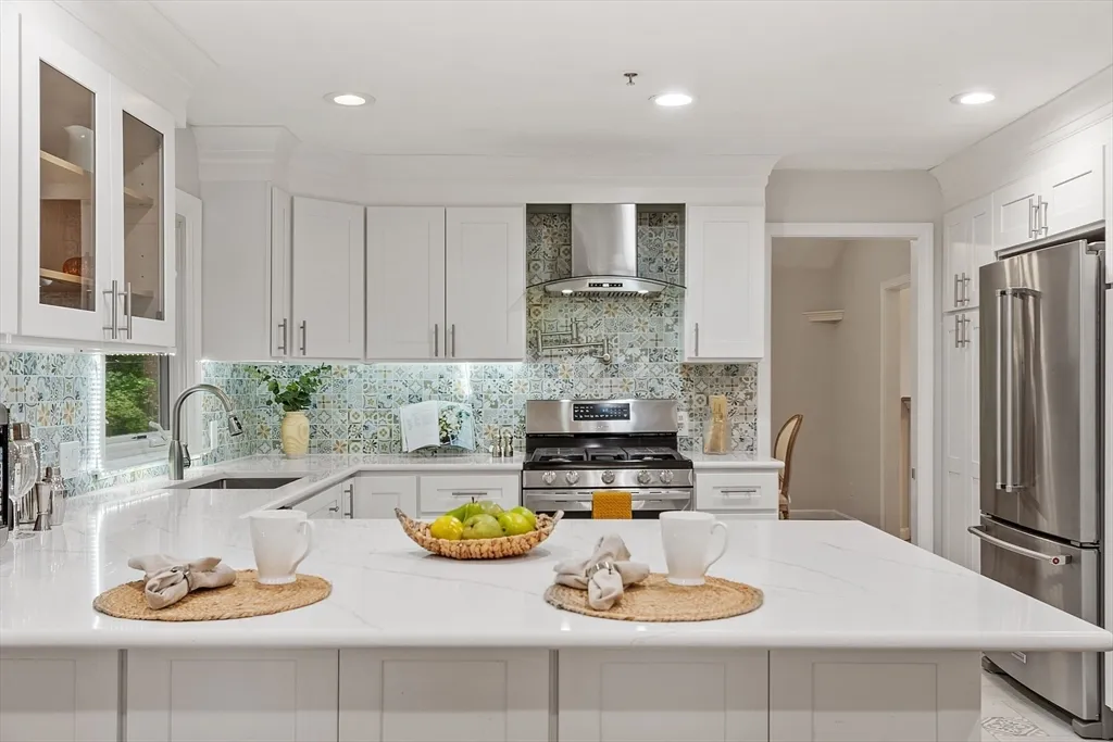 a kitchen with stainless steel appliances a table and chairs in it