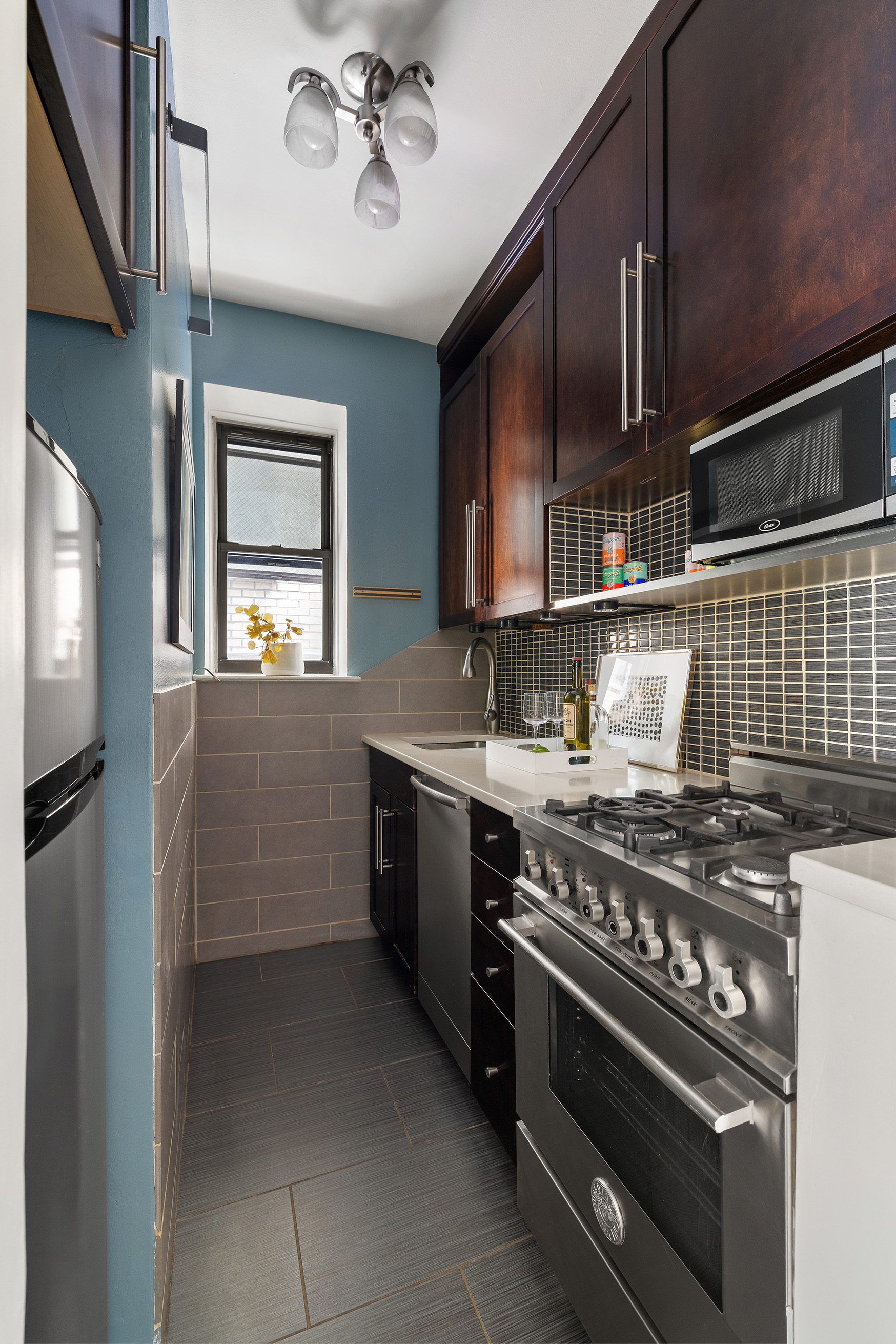 207 East 21st Street, Unit 2A Manhattan, NY 10010 - Photo 4 of 7 a kitchen with a stove and a microwave