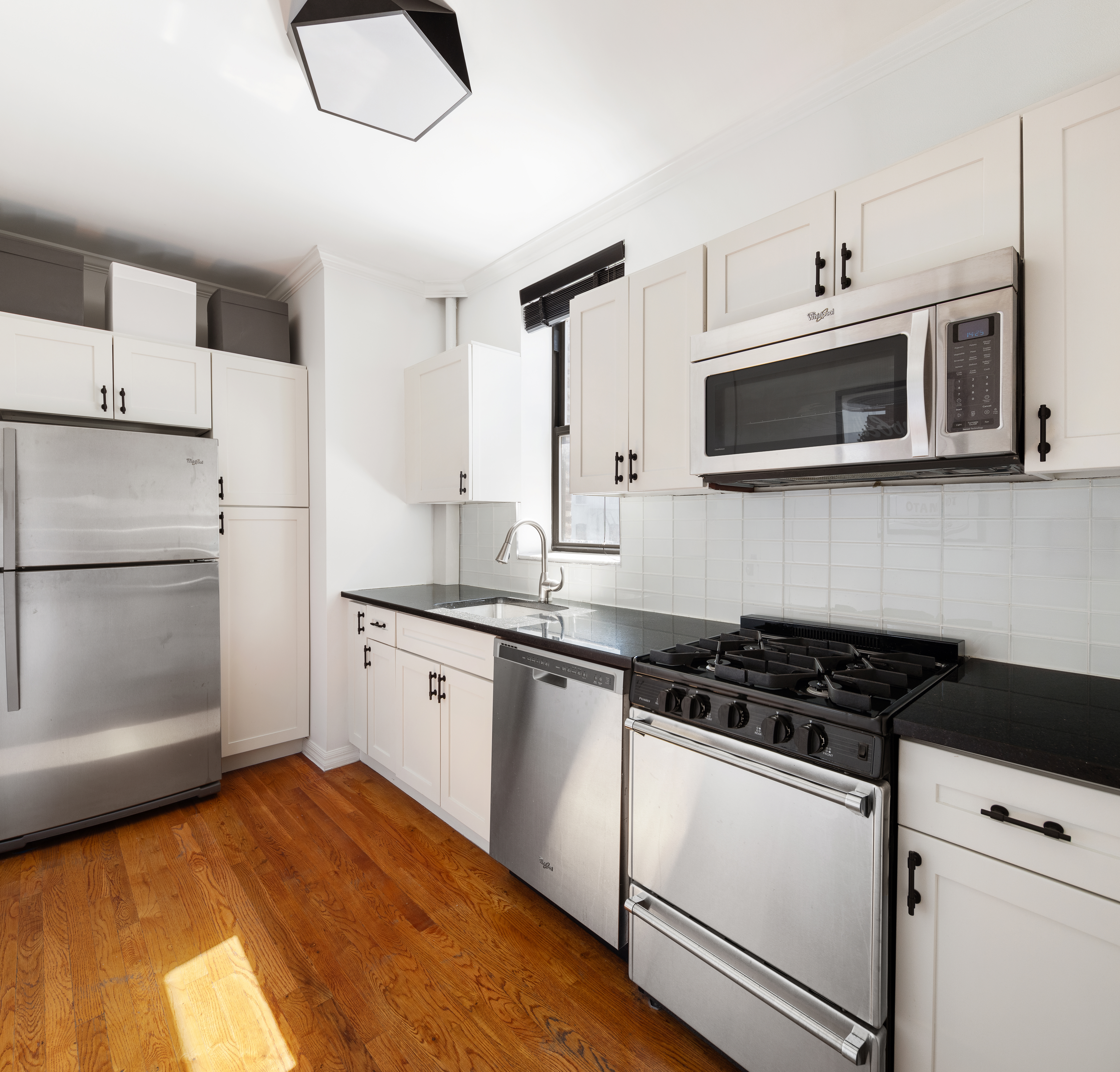 28 Perry Street, Unit 4W Manhattan, NY 10014 - Photo 4 of 7 a kitchen with stainless steel appliances granite countertop a stove and a microwave
