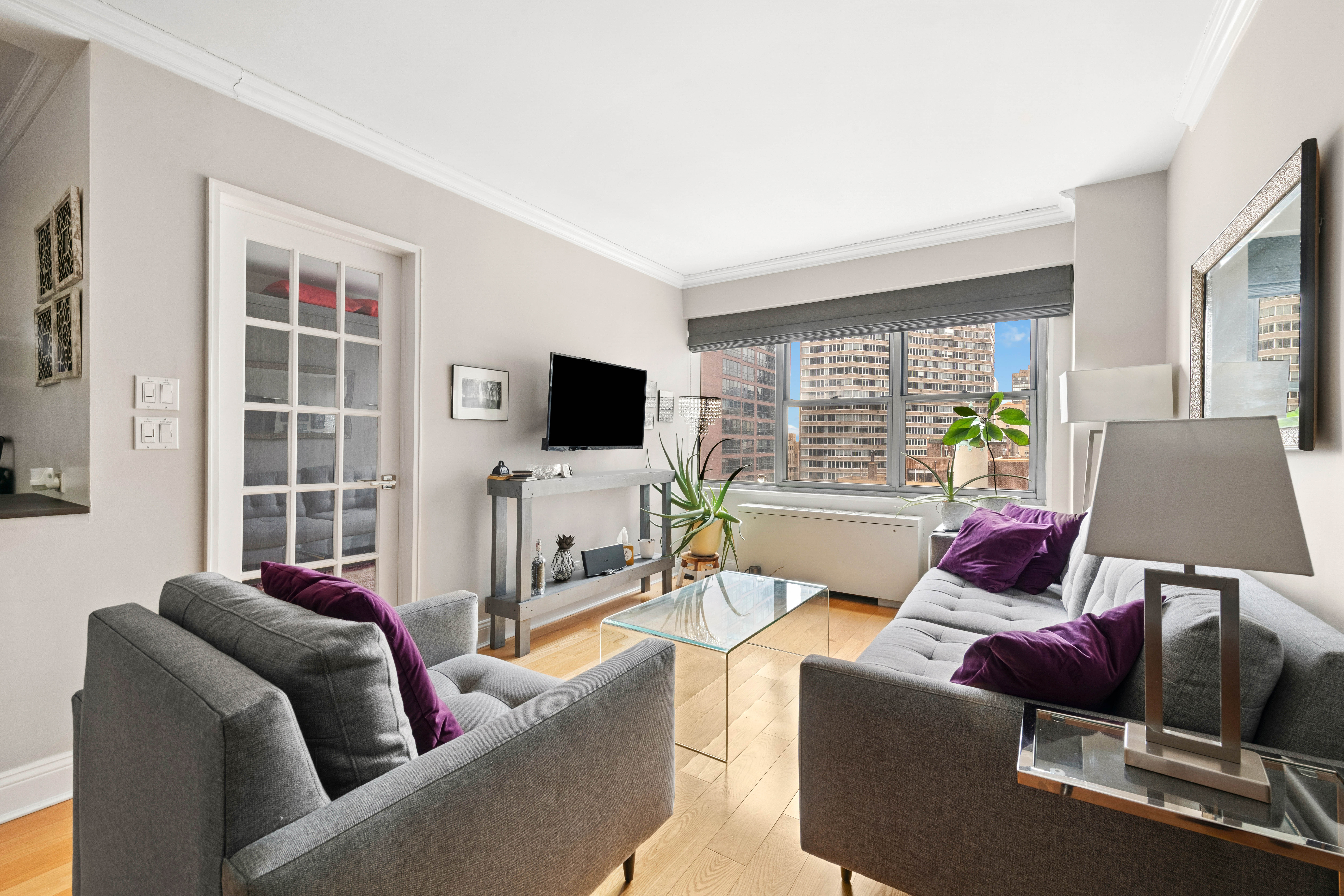 400 East 56th Street, Unit 19O Manhattan, NY 10022 - Photo 2 of 20 a living room with furniture and a flat screen tv