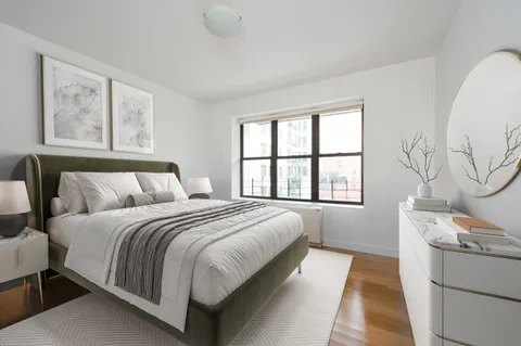 a bedroom with a large bed and a window