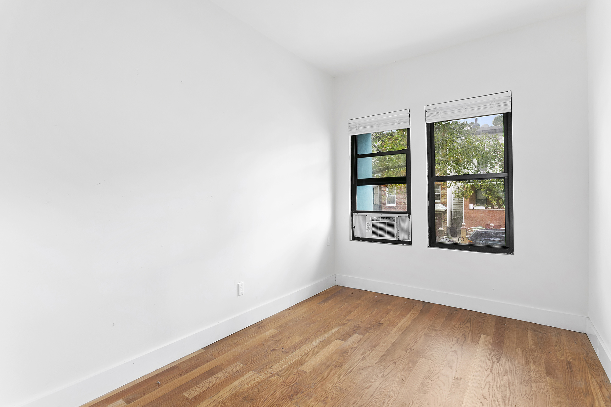 342 East 9th Street Brooklyn, NY 11218 - Photo 5 of 12 an empty room with wooden floor and windows