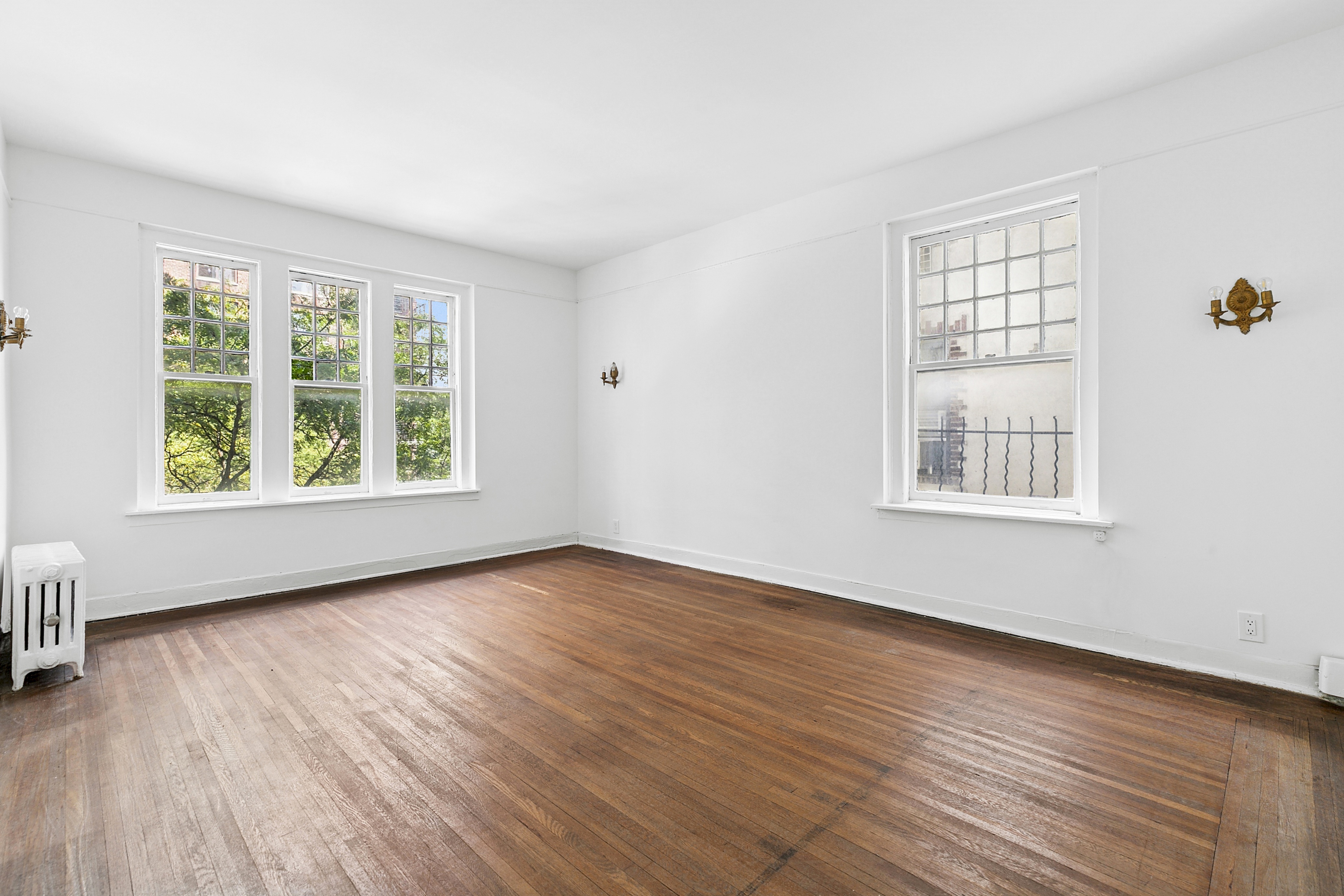 370 Central Park West, Unit 413 Manhattan, NY 10025 - Photo 2 of 19 a view of an empty room with wooden floor and windows