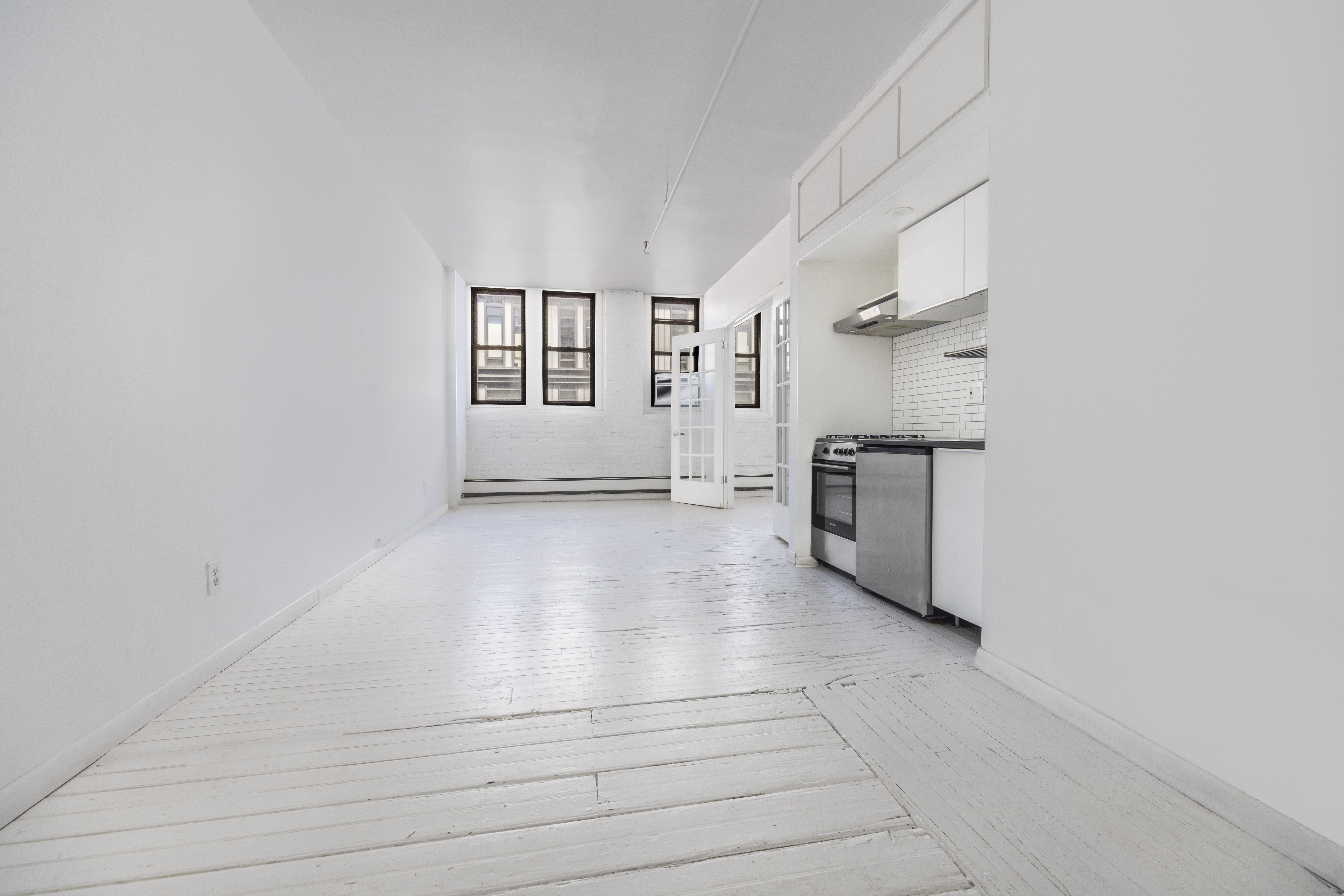 10 Leonard Street, Unit 6N Manhattan, NY 10013 - Photo 8 of 12 an empty room with windows and fireplace