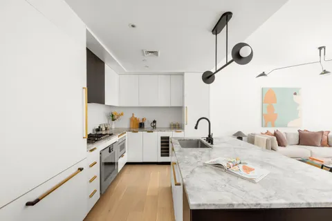 a kitchen with granite countertop a sink a stove and cabinets