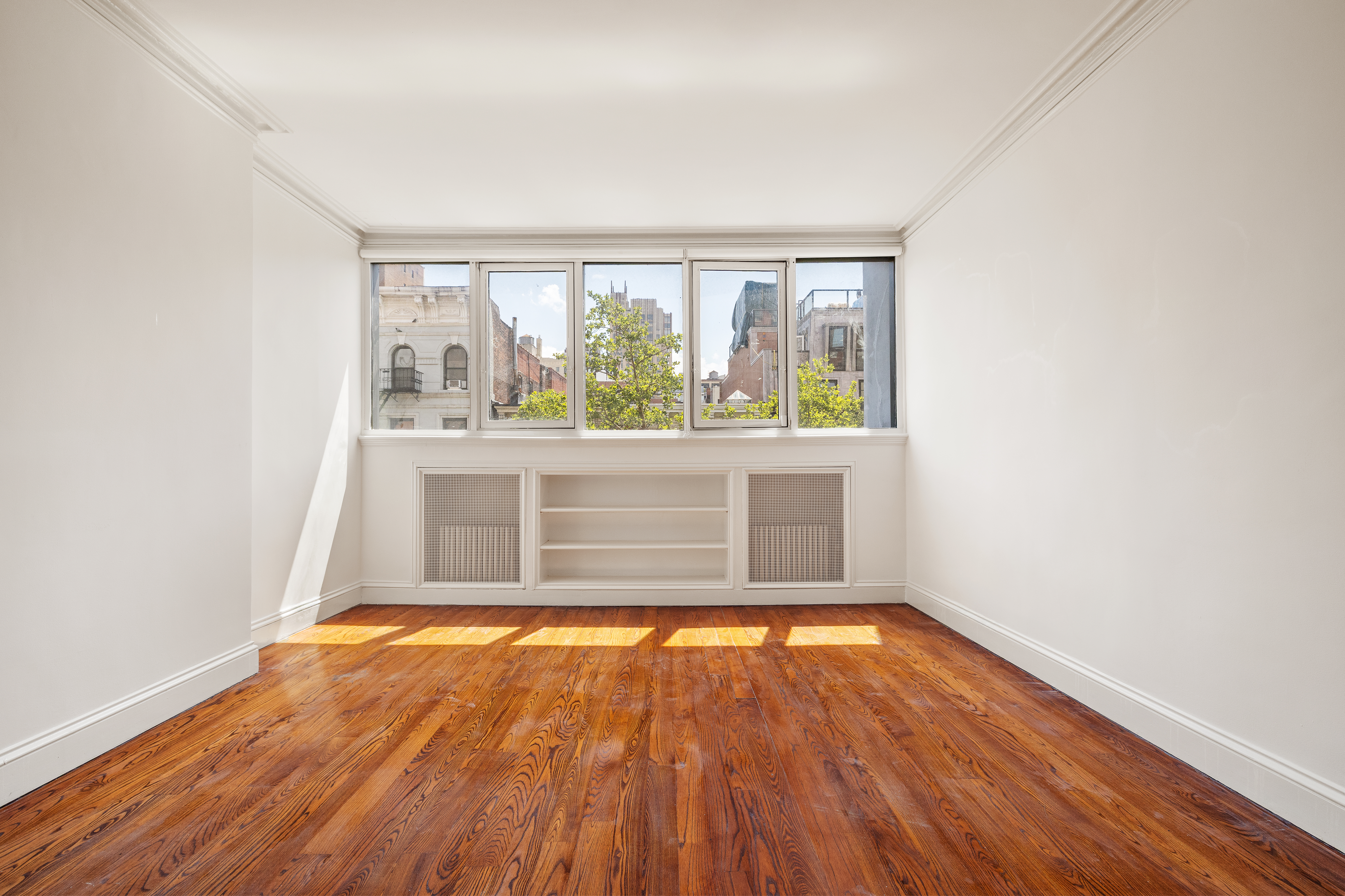 225 West 22nd Street Manhattan, NY 10011 - Photo 10 of 12 an empty room with wooden floor and windows