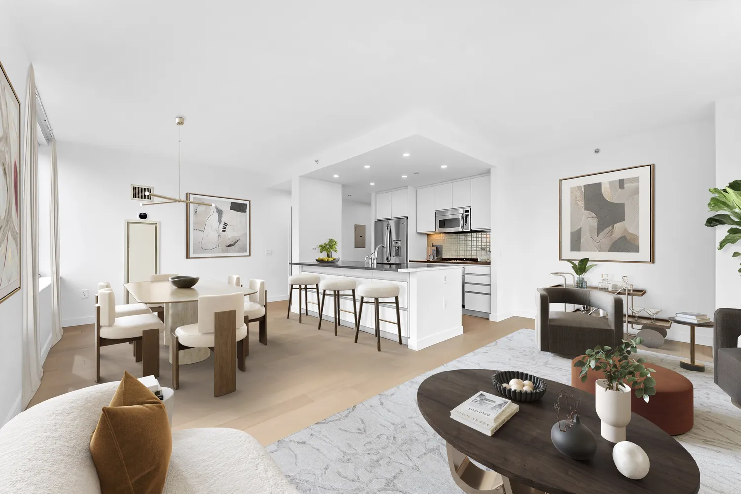 a living room with couches a coffee table and kitchen view with wooden floor