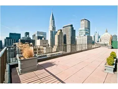 a view of terrace with lawn chairs and iron fence