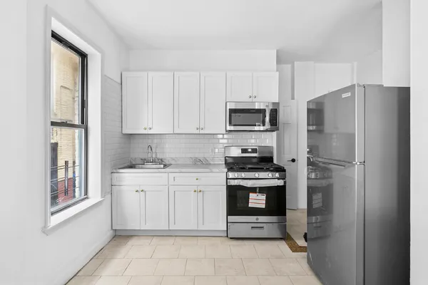 a kitchen with stainless steel appliances granite countertop a refrigerator stove and sink