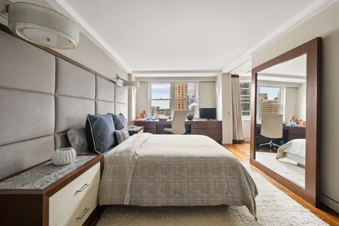 a bedroom with a bed and large window with balcony view