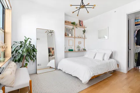 a bedroom with a large bed and a chandelier