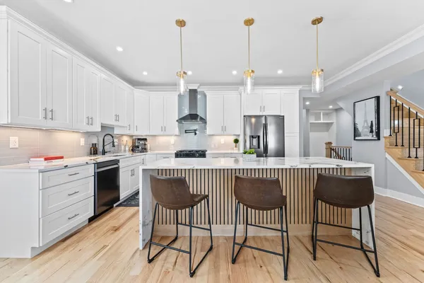 a kitchen with kitchen island granite countertop a sink a center island and cabinets