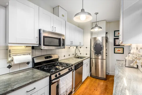 a kitchen with stainless steel appliances granite countertop a stove and a refrigerator