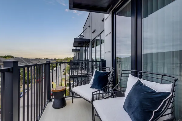 a view of balcony with couch and chairs