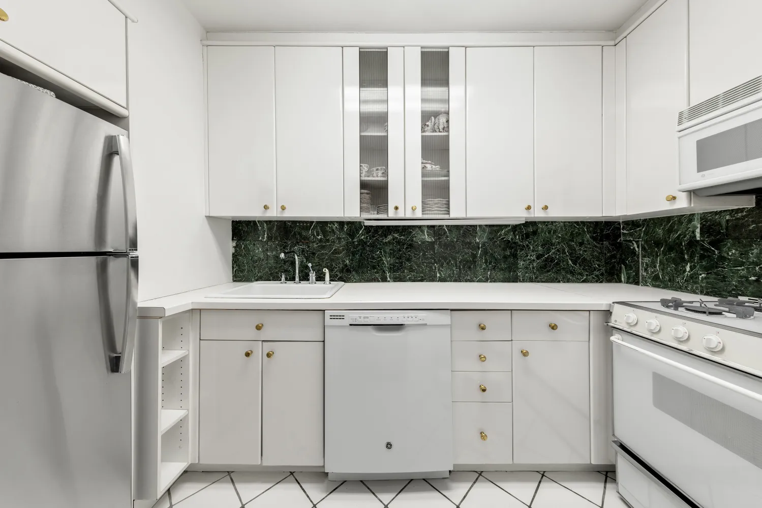 a view of cabinets with stainless steel appliances granite countertop white cabinets and window