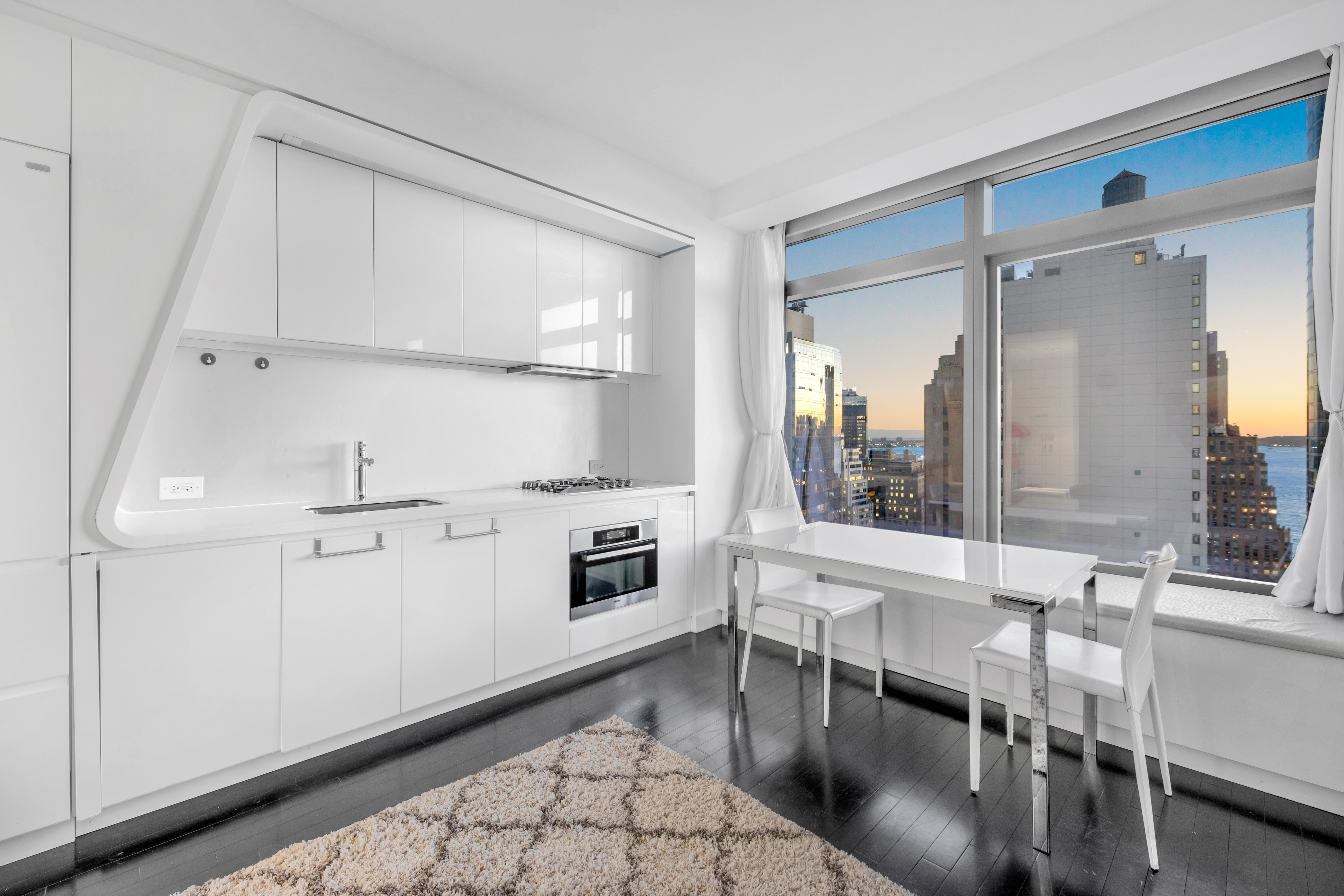 123 Washington Street, Unit 36H Manhattan, NY 10006 - Photo 2 of 8 a kitchen with stainless steel appliances granite countertop a stove a sink and white cabinets with wooden floor